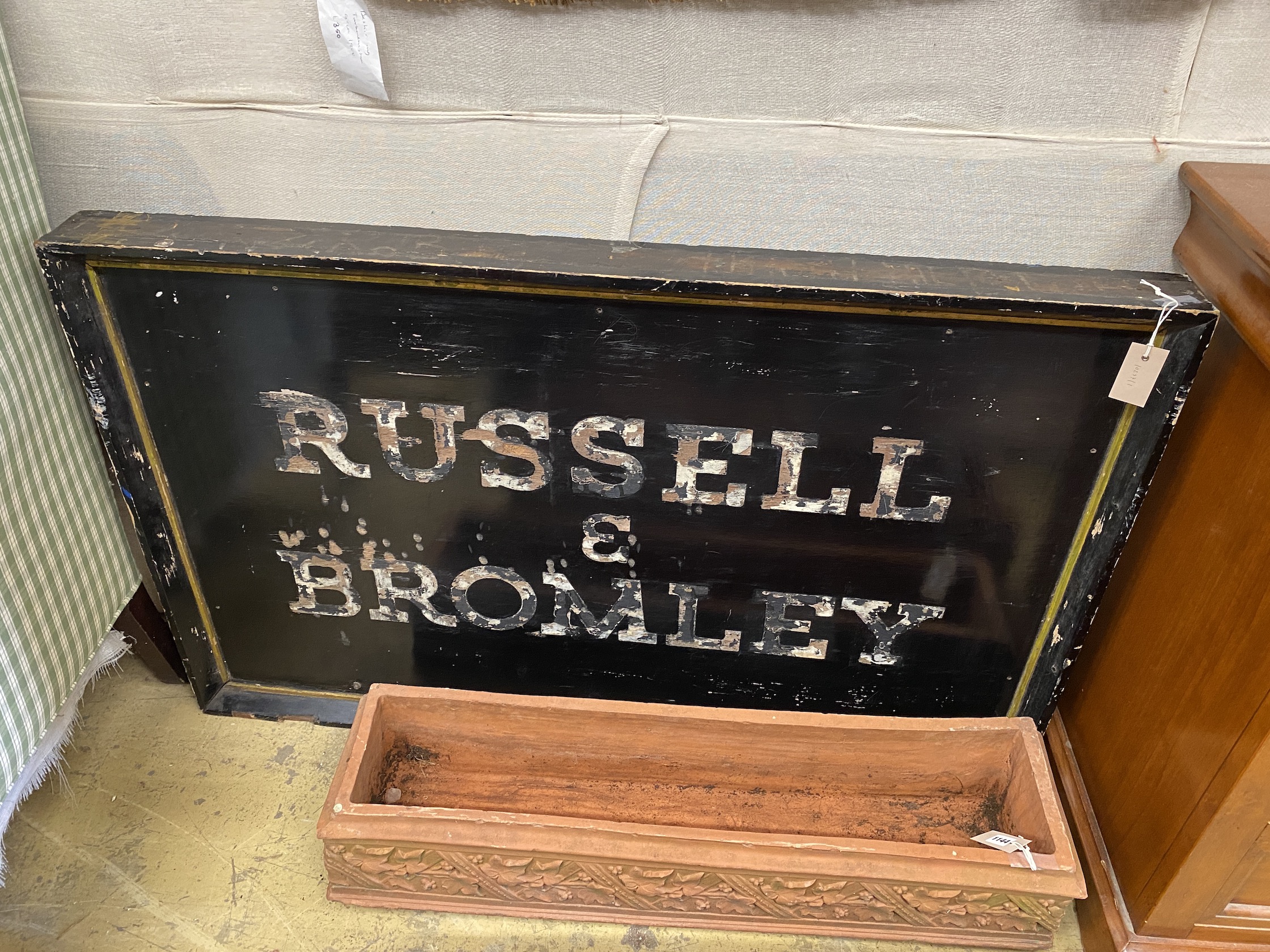 A vintage rectangular painted 'Russell & Bromley' advertising sign, length 123cm, height 78cm